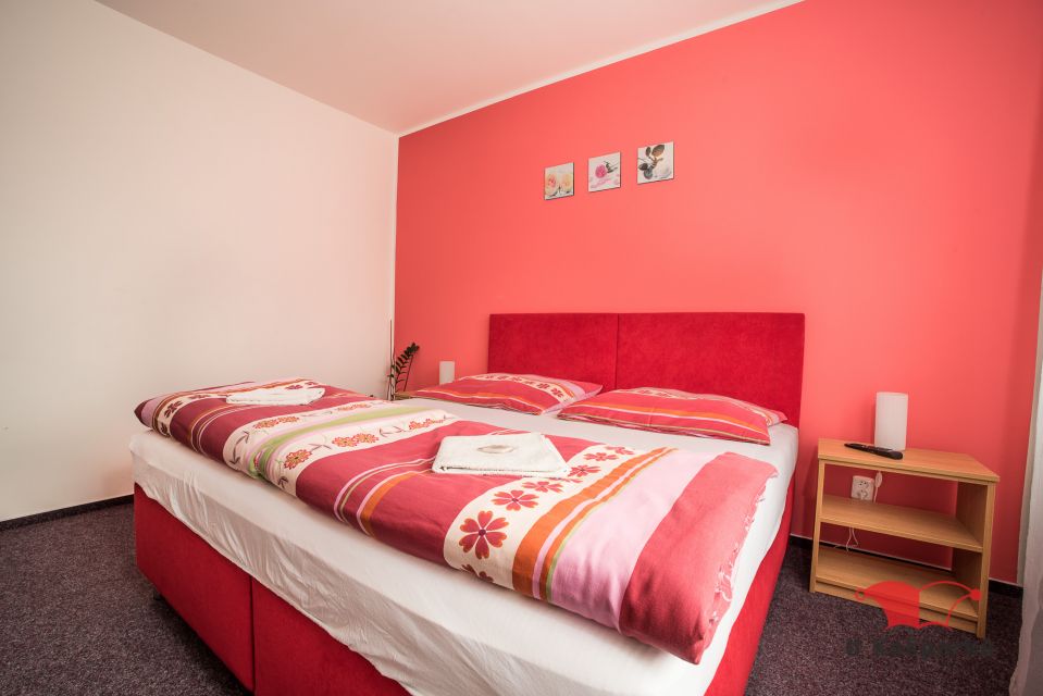 Double room with a red wall behind the headboard